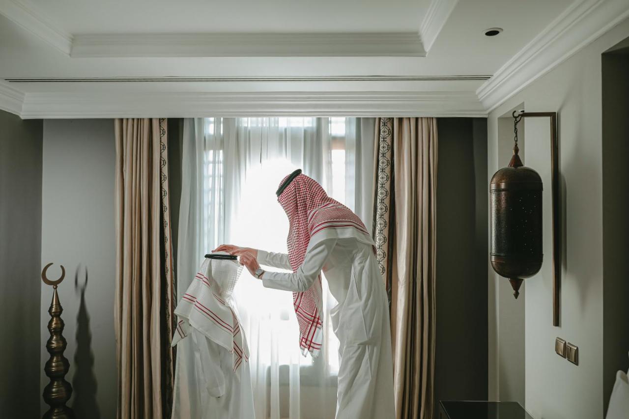 Готель Sofitel Shahd Al Madinah Medina Екстер'єр фото The photo shows two individuals dressed in traditional clothing, commonly associated with Arabian culture. One person is standing and wearing a headscarf, while the other person is seated or positioned at a lower height, potentially wearing a similar